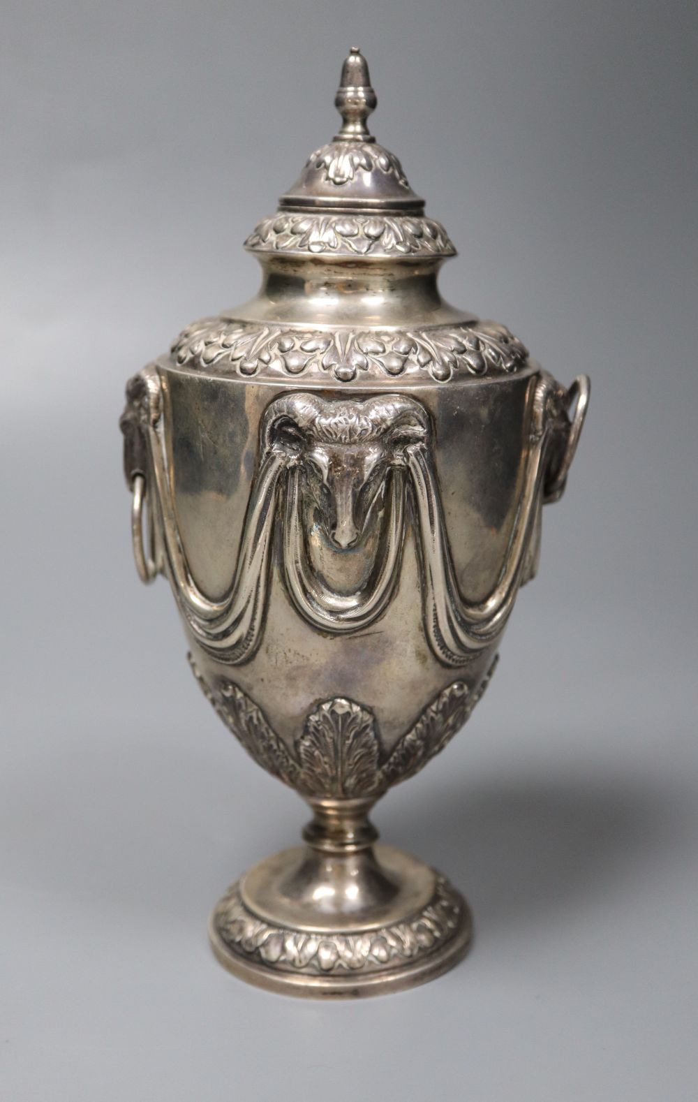 A George V silver vase and cover, with rams head and swag decoration and two ring handles, William Hutton & Sons, Sheffield, 1910,